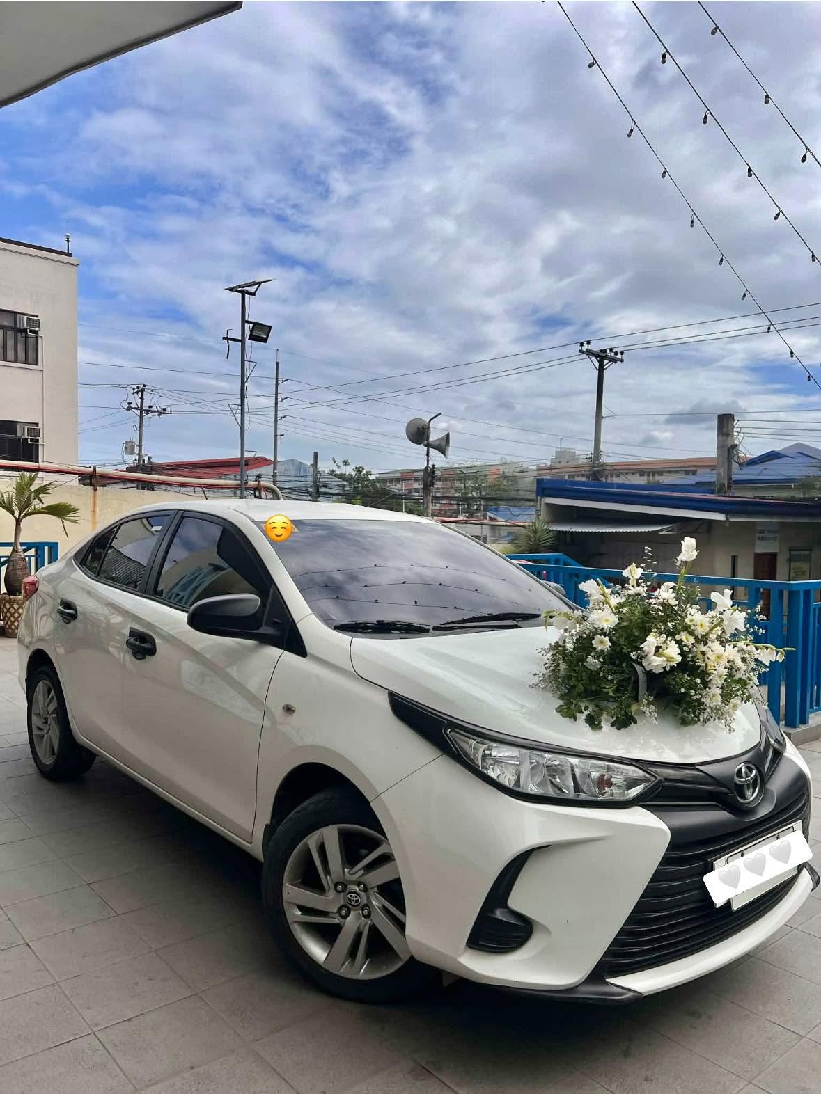 White Toyota Vios dressed with white flowers for a wedding booking